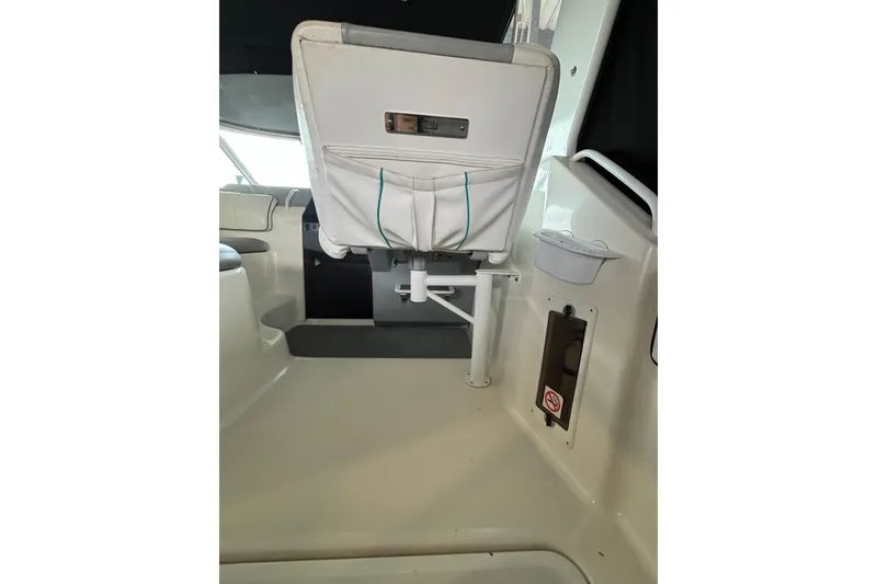 Slide: The Image of 1992 Tiara Sport 270 Sport boat interior with white seating and storage compartments. - 7