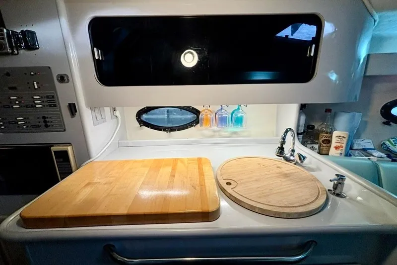 Slide: The Image of Compact kitchen area in a 1992 Tiara Sport 270 Sport boat with cutting boards and sink. - 27
