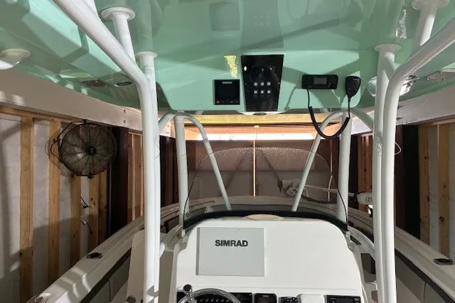 Slide: The Image of 2021 Aquasport 2500 Center Console boat interior with Simrad electronics in a garage. - 33