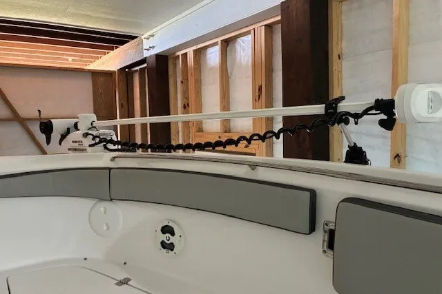 Slide: The Image of 2021 Aquasport 2500 Center Console boat interior with mounted equipment in a wooden structure. - 14
