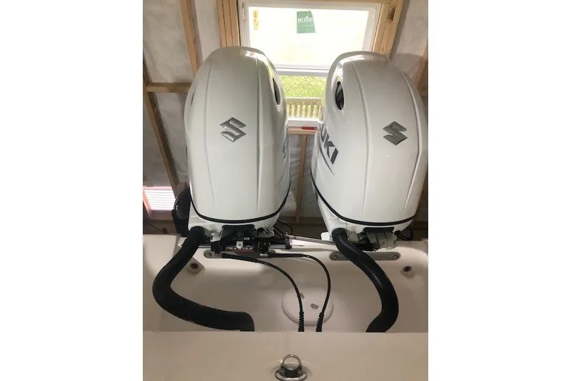 Slide: The Image of Twin Suzuki outboard engines on a 2021 Aquasport 2500 Center Console boat. - 5