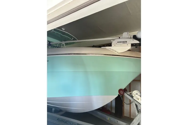 Slide: The Image of 2021 Aquasport 2500 Center Console boat in storage, featuring a Minn Kota trolling motor. - 3