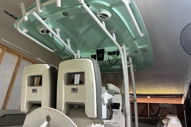 Slide: The Image of 2021 Aquasport 2500 Center Console boat interior with dual seats and overhead rod holders. - 34
