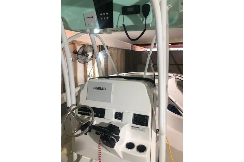 Slide: The Image of 2021 Aquasport 2500 Center Console boat interior with Simrad electronics and steering wheel. - 25
