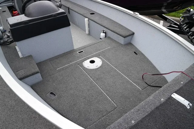Slide: The Image of The image shows the interior of a 2023 Lund 1600 Fury SS boat with gray carpeting. - 6