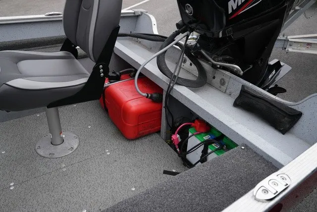 Slide: The Image of The image shows the interior of a 2023 Lund 1600 Fury SS boat with an engine and red fuel tank. - 12