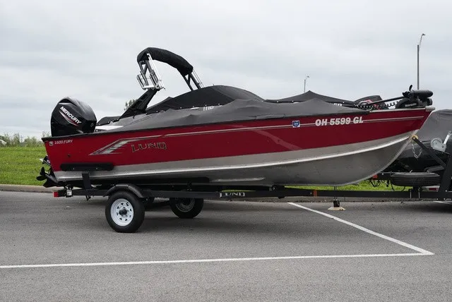 Slide: The Image of A red 2023 Lund 1600 Fury SS boat on a trailer. - 2
