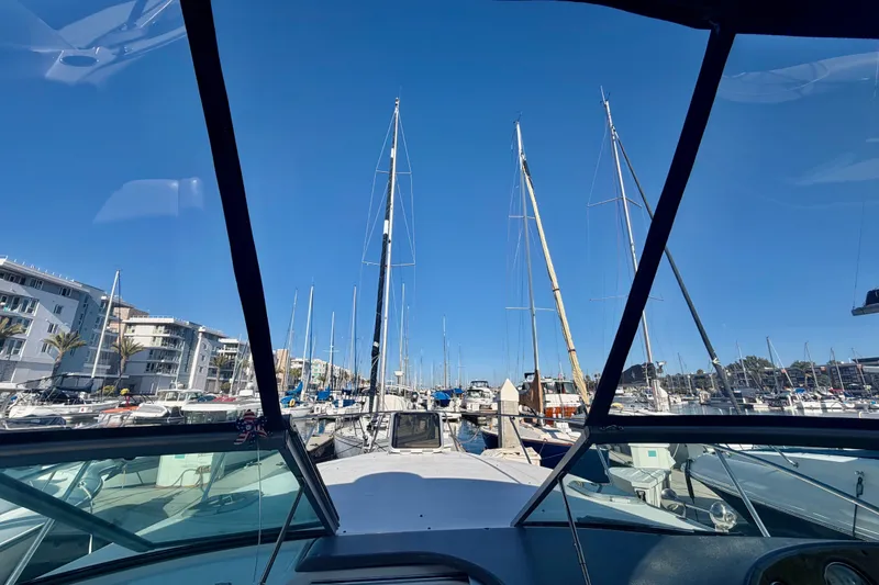 Slide: The Image of View from 2006 Rinker 320 Express Cruiser in marina, surrounded by sailboats and clear blue sky. - 13