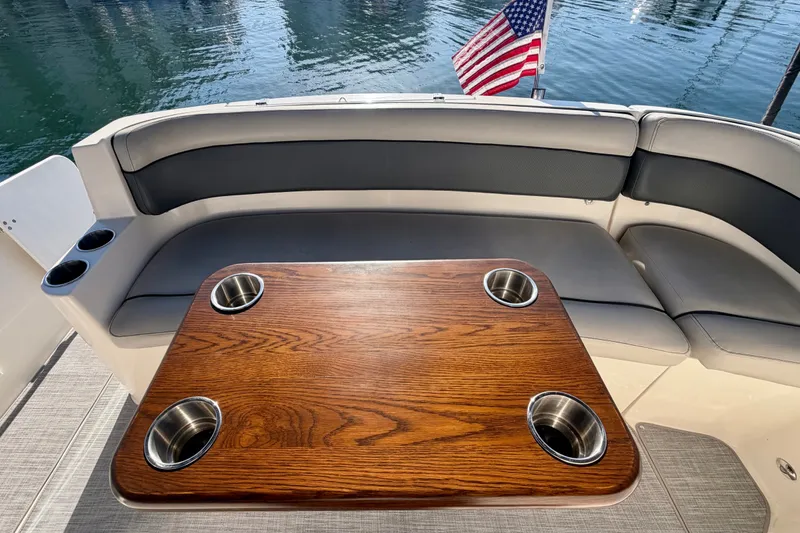 Slide: The Image of 2006 Rinker 320 Express Cruiser interior with wooden table and cushioned seating. - 35
