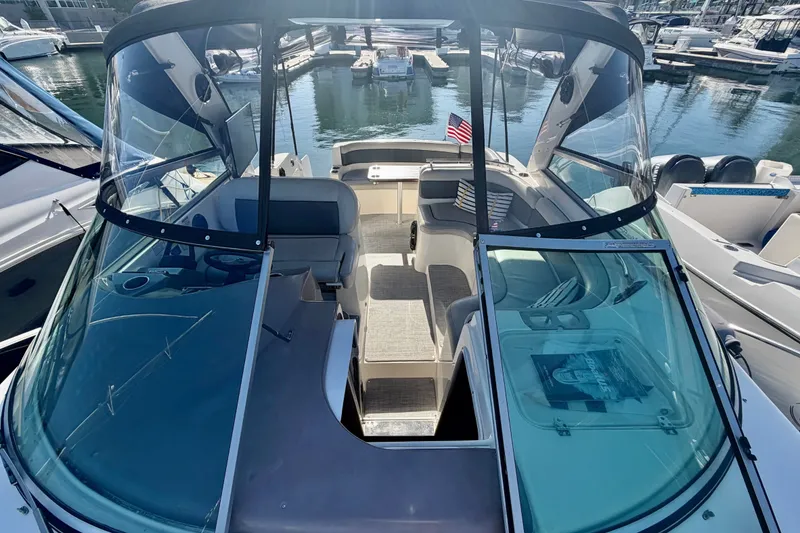 Slide: The Image of 2006 Rinker 320 Express Cruiser docked at marina, showcasing spacious cockpit and seating area. - 23