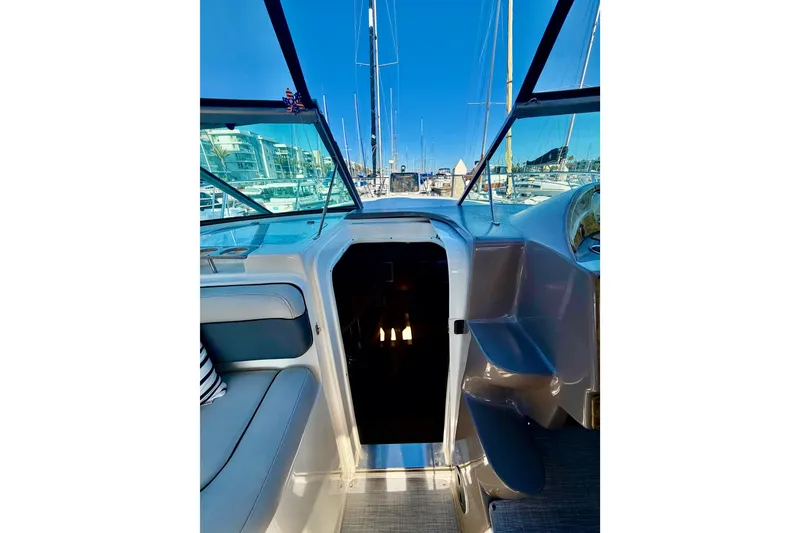 Slide: The Image of 2006 Rinker 320 Express Cruiser cockpit view with marina background. - 33