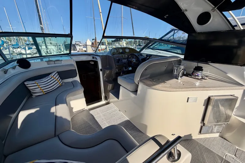 Slide: The Image of 2006 Rinker 320 Express Cruiser interior with helm, seating, and modern amenities in a marina setting. - 37