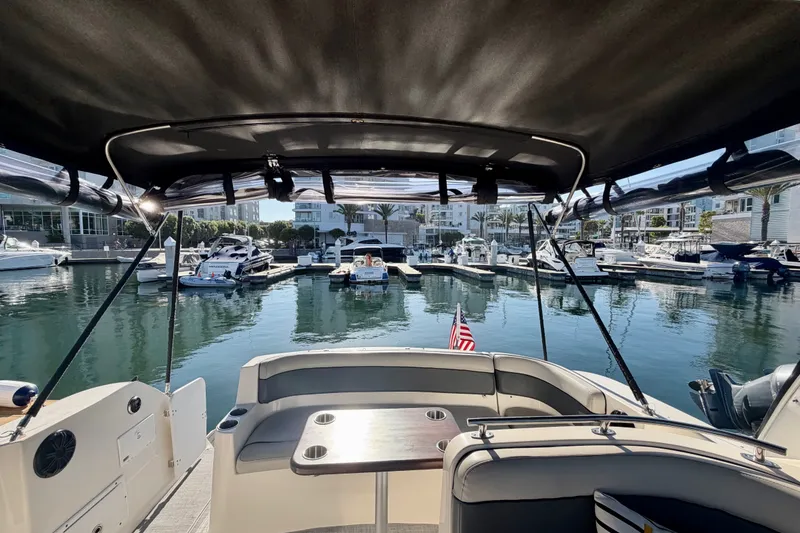 Slide: The Image of 2006 Rinker 320 Express Cruiser docked in a marina, featuring a spacious seating area. - 21