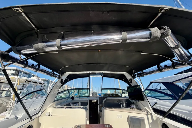 Slide: The Image of 2006 Rinker 320 Express Cruiser interior with canopy, docked at marina. - 34