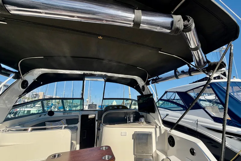 Slide: The Image of 2006 Rinker 320 Express Cruiser interior with canopy, docked at marina. - 32