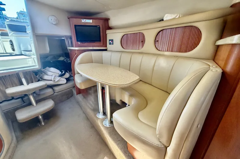 Slide: The Image of Interior of 2006 Rinker 320 Express Cruiser with beige seating and compact dining area. - 46