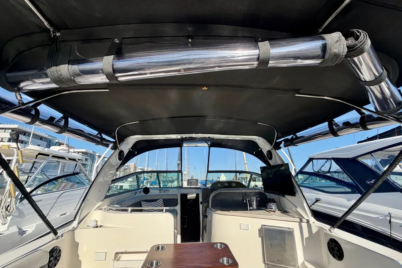 Slide: The Image of 2006 Rinker 320 Express Cruiser interior with canopy, docked at marina. - 30