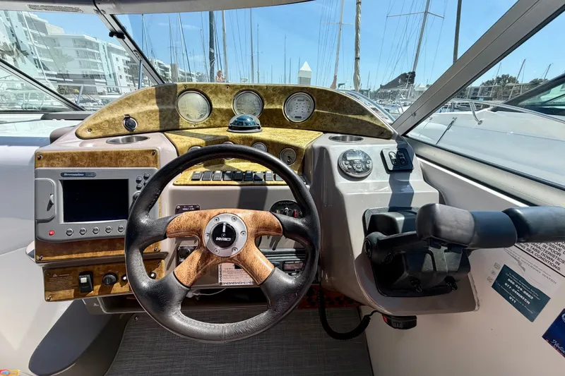 Slide: The Image of Helm of 2006 Rinker 320 Express Cruiser with steering wheel and control panel. - 40