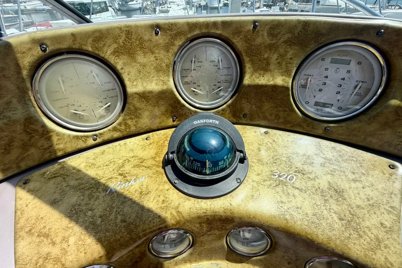 Slide: The Image of Dashboard of a 2006 Rinker 320 Express Cruiser with gauges and compass. - 41