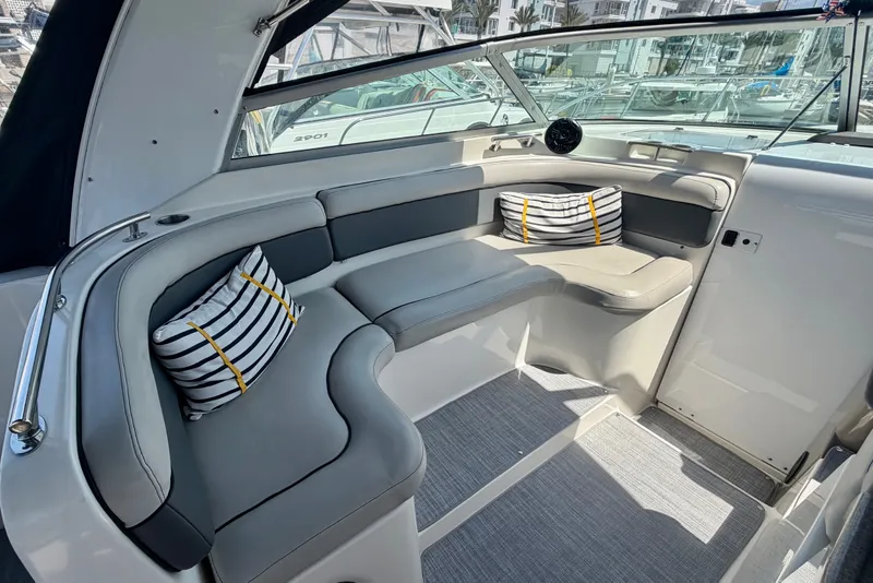 Slide: The Image of 2006 Rinker 320 Express Cruiser interior with gray seating and striped cushions. - 36