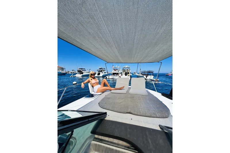 Slide: The Image of Woman relaxing on a 2006 Rinker 320 Express Cruiser yacht under a sunshade. - 14