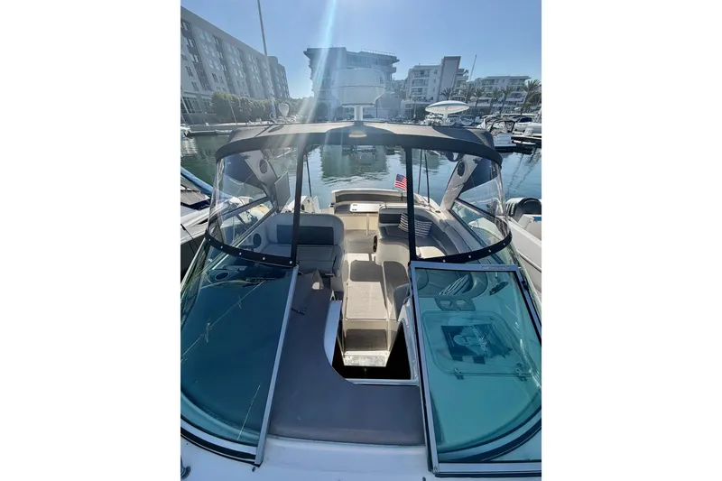 Slide: The Image of 2006 Rinker 320 Express Cruiser docked in a marina, showcasing spacious seating and sleek design. - 24