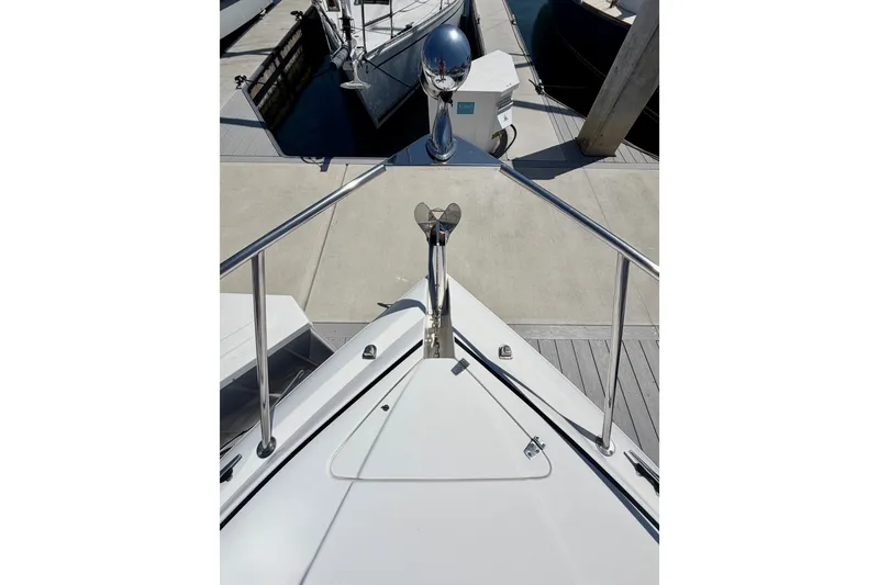 Slide: The Image of 2006 Rinker 320 Express Cruiser bow view at marina dock. - 15