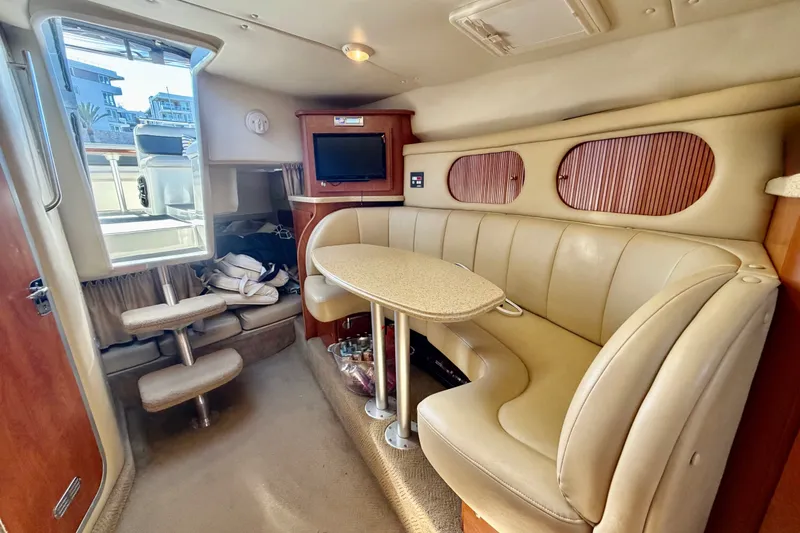 Slide: The Image of Interior of 2006 Rinker 320 Express Cruiser with beige seating and compact dining area. - 48