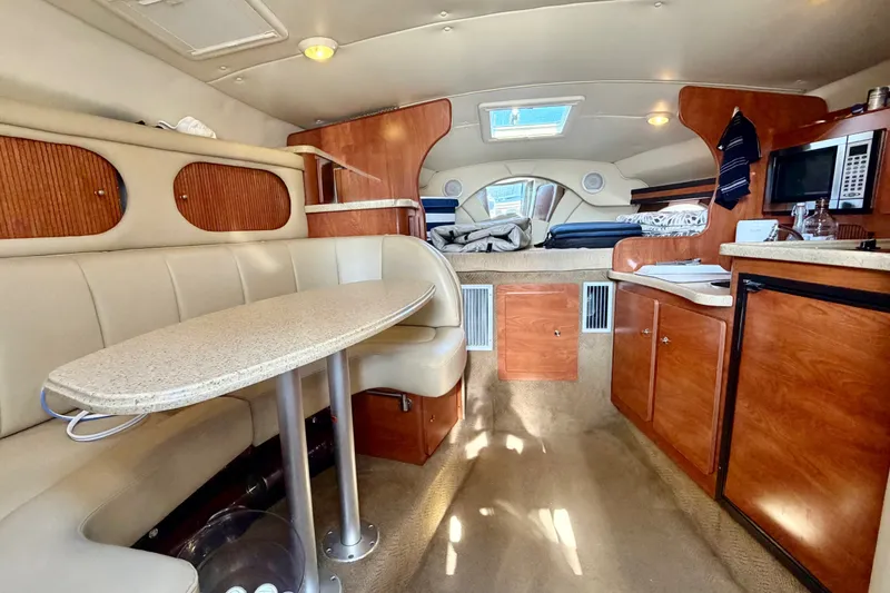 Slide: The Image of 2006 Rinker 320 Express Cruiser interior with seating, kitchenette, and sleeping area. - 45