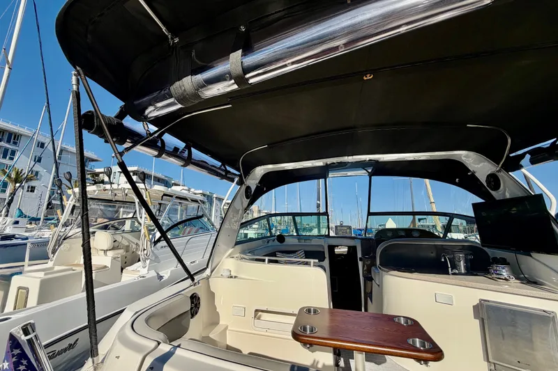 Slide: The Image of 2006 Rinker 320 Express Cruiser interior with seating, table, and marina view. - 31