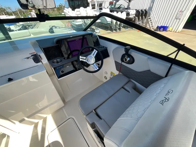 Slide: The Image of The image shows the cockpit of a 2021 Sea Ray SDX 250 Outboard with gray seating. - 34
