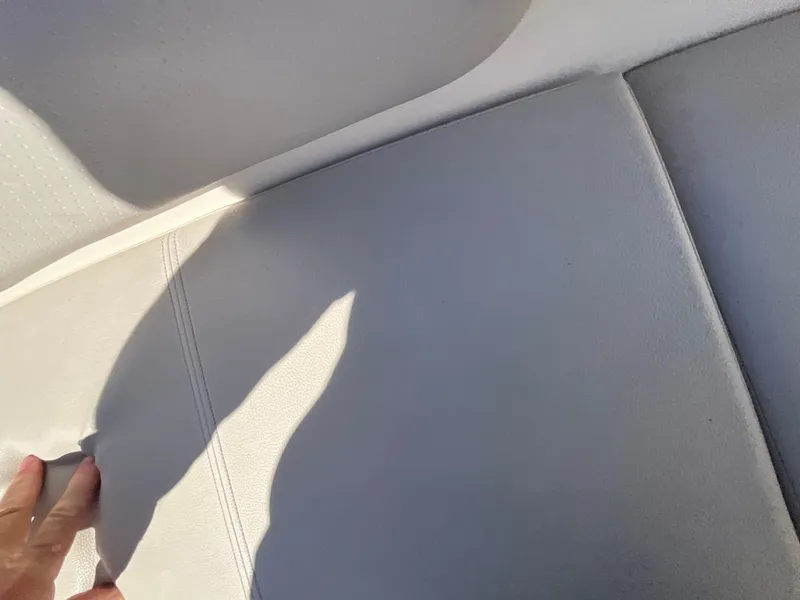 Slide: The Image of Close-up of a light gray boat seat with a hand touching the fabric. - 10