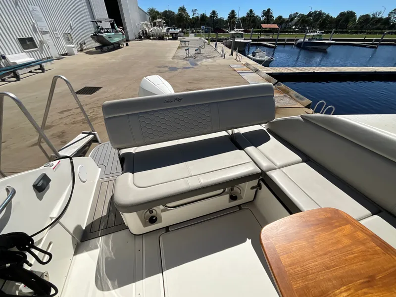 Slide: The Image of The image shows the cockpit of a 2021 Sea Ray SDX 250 Outboard with beige upholstery. - 27