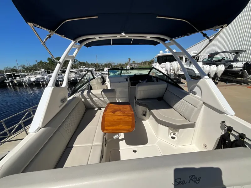 Slide: The Image of The image shows the cockpit of a Sea Ray SDX 250 Outboard with beige seats and a wooden table. - 30