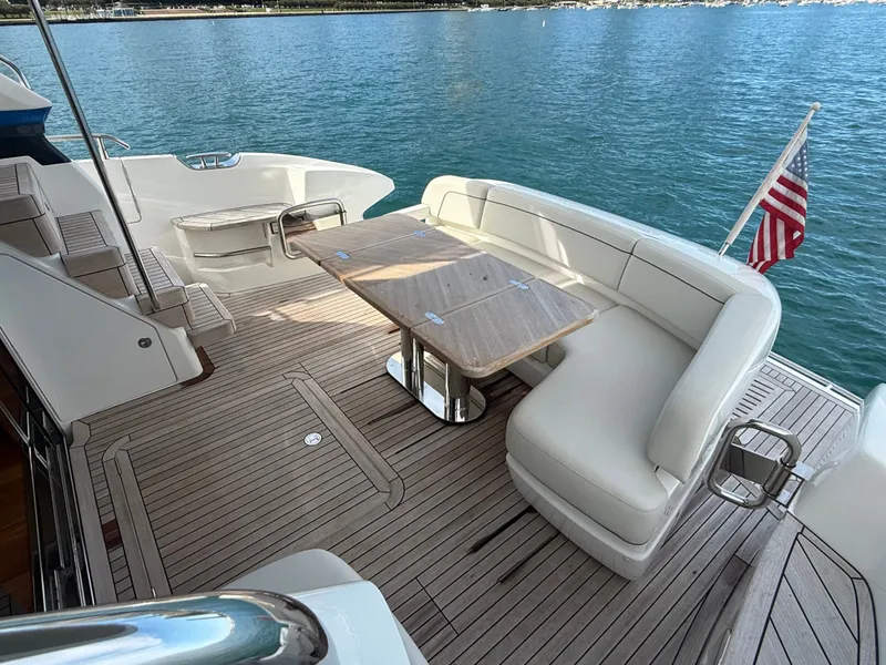 Slide: The Image of The image shows the aft deck of a 2023 Princess F45 yacht with an elegant seating area and table. - 12