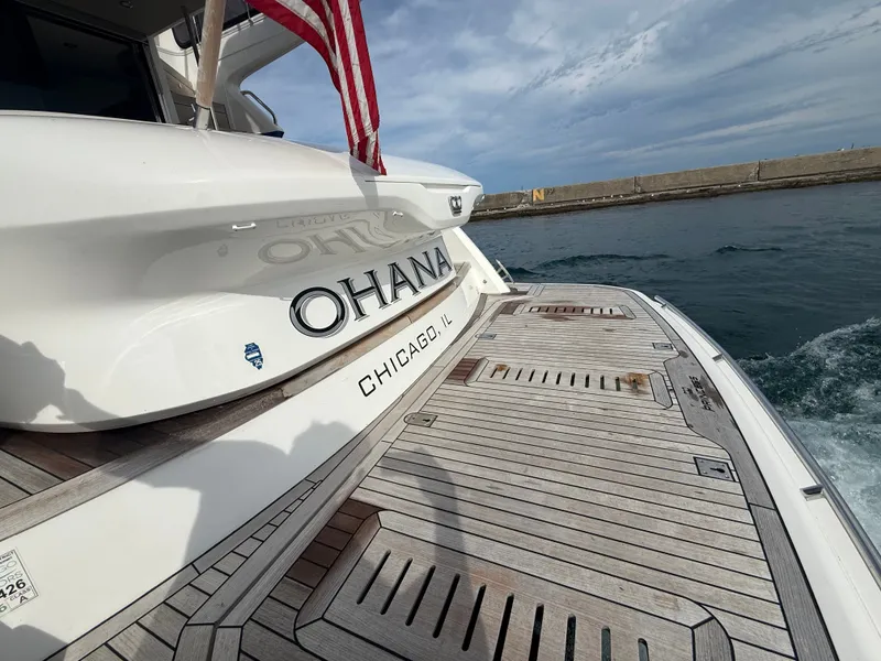 Slide: The Image of The yacht "Ohana" with a wooden deck is cruising in a harbor with calm waters. - 7