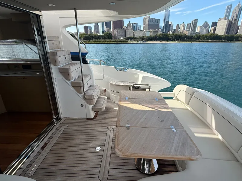 Slide: The Image of The 2023 Princess F45 features a sleek deck with a wooden table and city skyline view. - 10