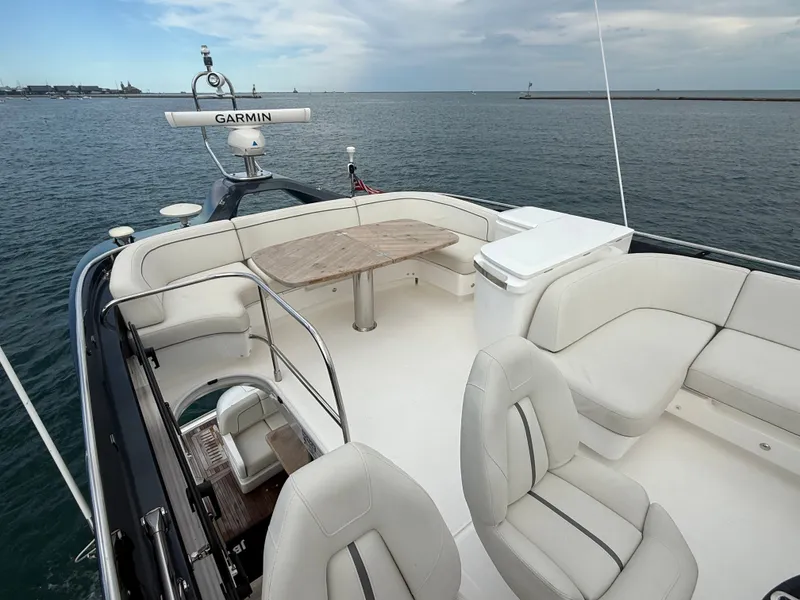 Slide: The Image of The image shows the deck of a 2023 Princess F45 yacht with white seating and a wooden table. - 30