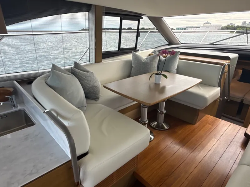 Slide: The Image of Interior of a luxury yacht with white leather sofa and wooden table, surrounded by windows. - 45