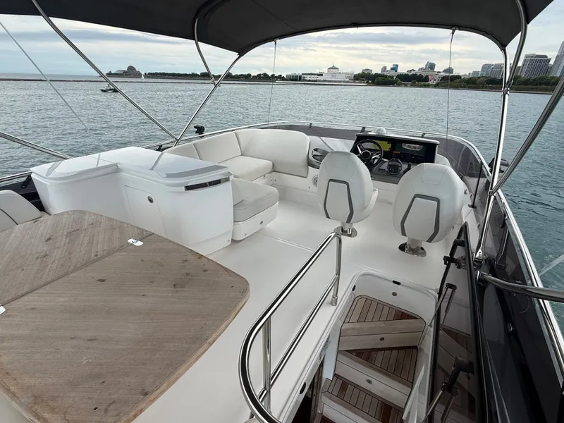 Slide: The Image of The image shows the deck of a 2023 Princess F45 yacht with seating area and helm. - 28