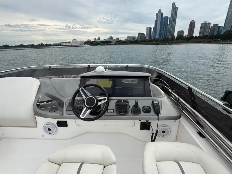 Slide: The Image of The image shows the helm of a 2023 Princess F45 yacht with a city skyline in the background. - 37