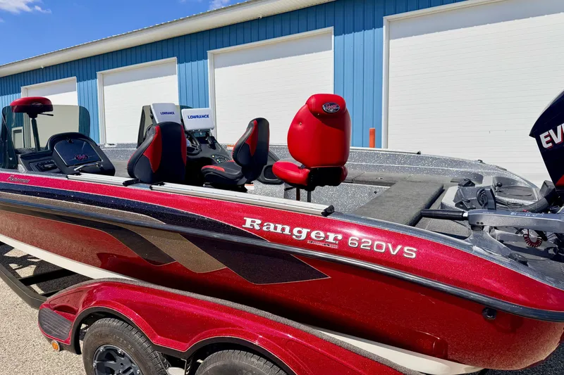 Slide: The Image of 2009 Ranger 620VS Fisherman boat with red exterior, parked near blue building. - 19