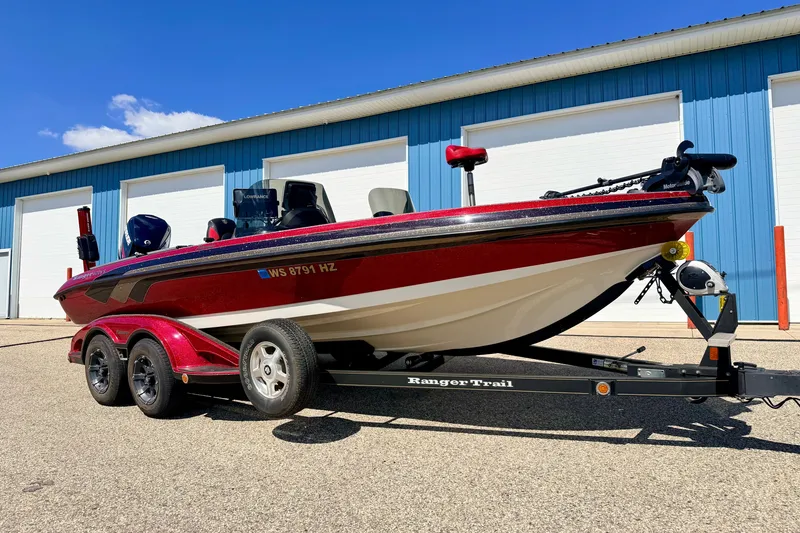Slide: The Image of 2009 Ranger 620VS Fisherman boat on trailer, parked outside blue building. - 2