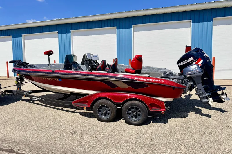 Slide: The Image of 2009 Ranger 620VS Fisherman boat with Evinrude motor, parked outdoors near blue building. - 5