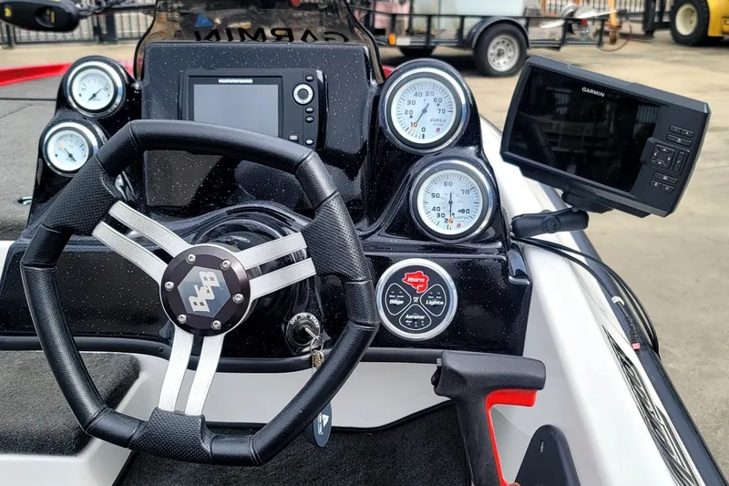 Slide: The Image of 2017 Bass Cat Margay boat dashboard with steering wheel, gauges, and Garmin display. - 3