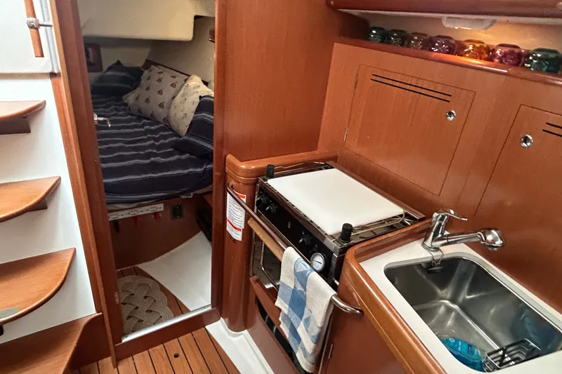 Slide: The Image of Interior of a 2009 Beneteau 343 sailboat featuring a cozy cabin and compact kitchen. - 28