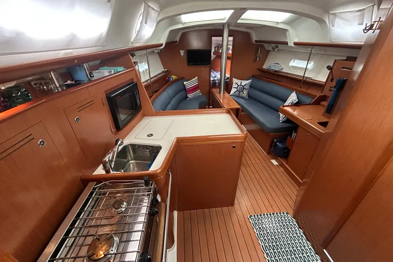 Slide: The Image of Interior of 2009 Beneteau 343 sailboat with wood finish, kitchen, and seating area. - 25