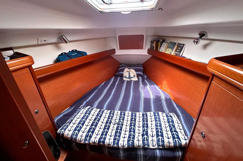 Slide: The Image of Cozy cabin interior of 2009 Beneteau 343 sailboat with striped bedding and books. - 30