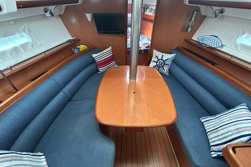 Slide: The Image of Interior of a 2009 Beneteau 343 sailboat with blue seating and wooden table. - 15