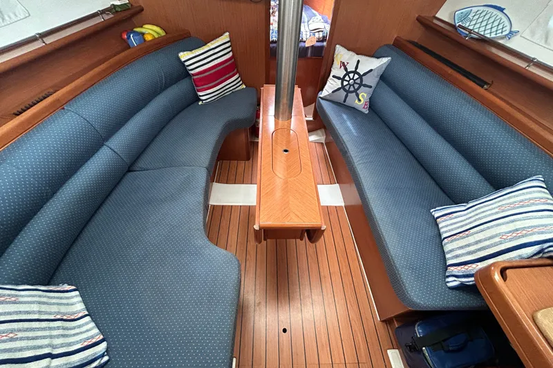 Slide: The Image of Interior of 2009 Beneteau 343 sailboat with blue seating and decorative pillows. - 14